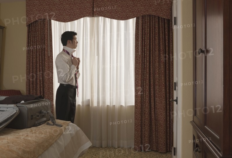 Chinese businessman undressing in hotel room