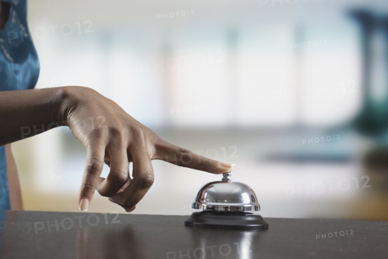 Black woman ringing reception desk bell