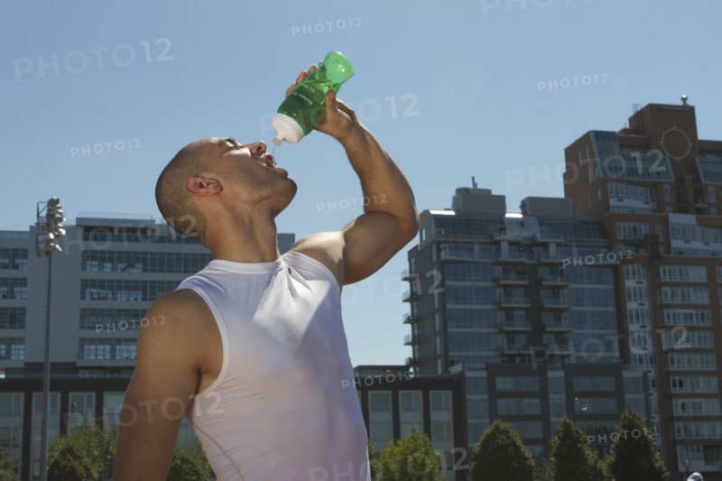 Mixed race athlete drinking water