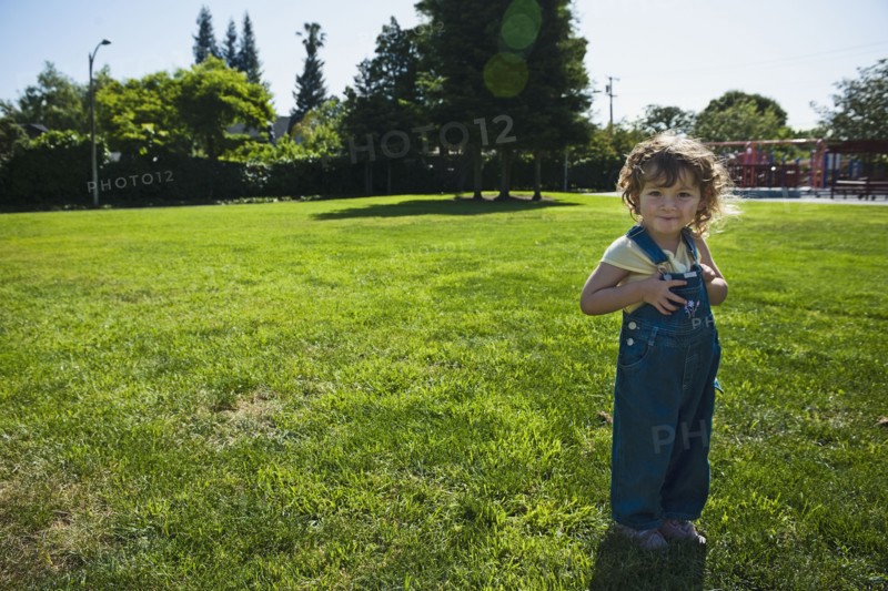 Mixed race girl wearing overalls in park