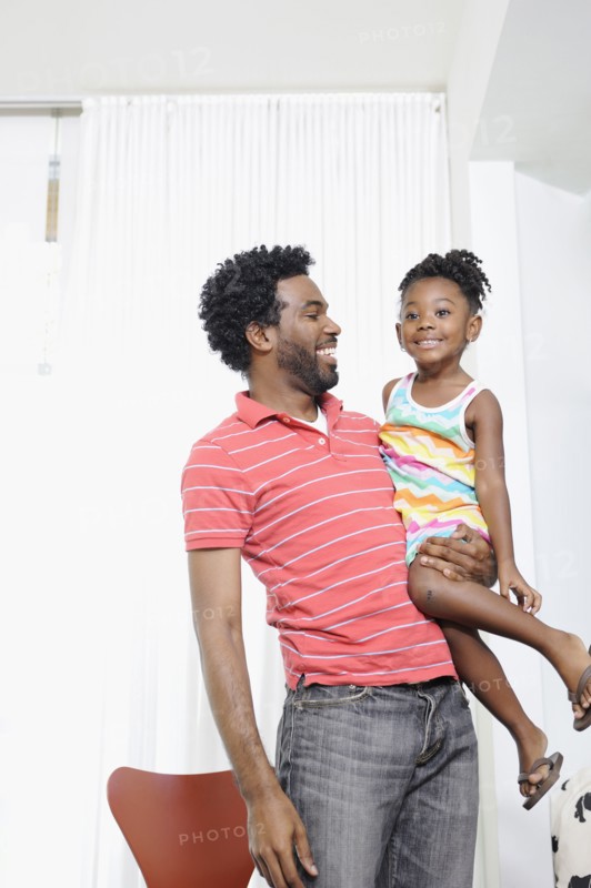 Black father holding daughter