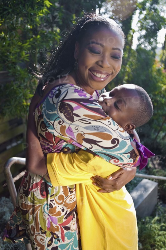 Black mother hugging son outdoors