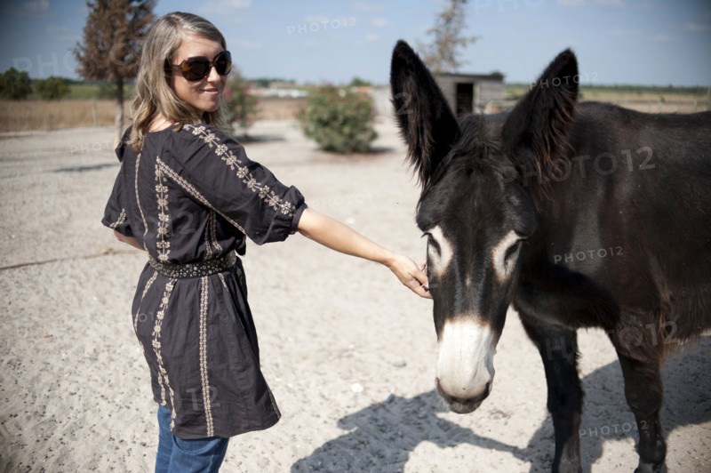 Caucasian woman petting donkey
