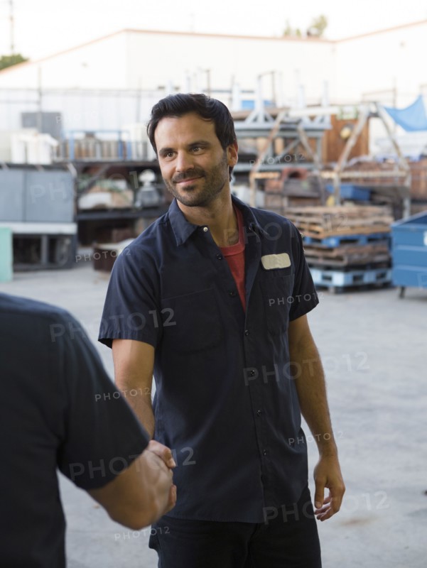 Workers shaking hands in warehouse