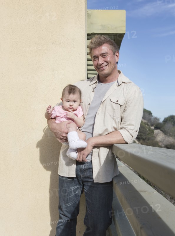 Father holding baby girl outdoors