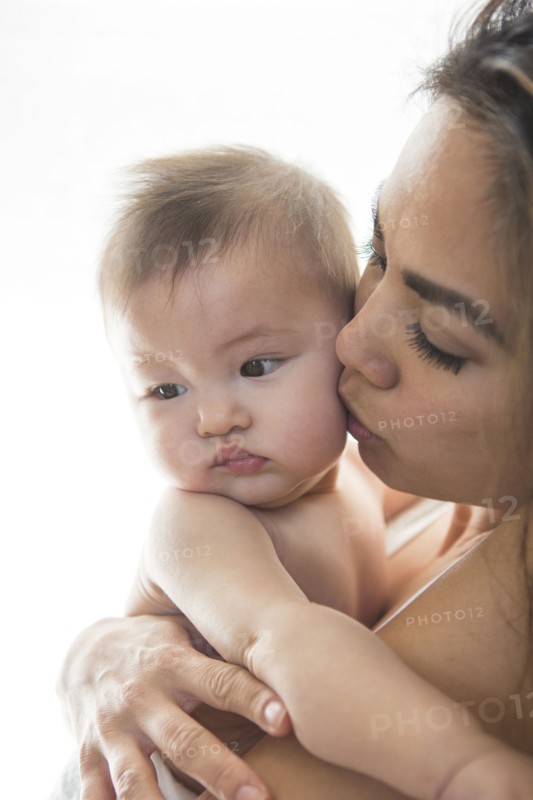 Mother kissing baby girl's cheek