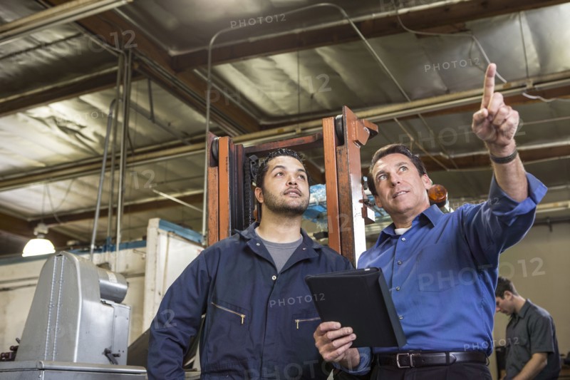 Worker and businessman talking in warehouse