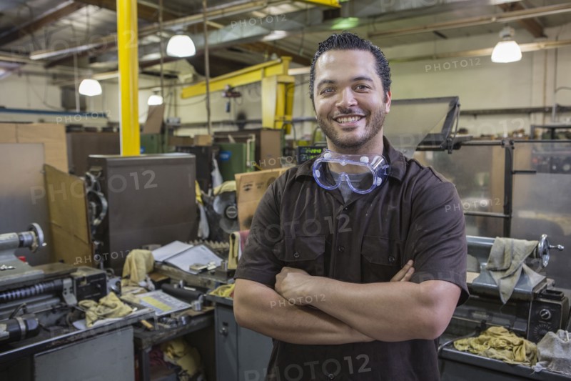 Hispanic worker smiling in repair shop