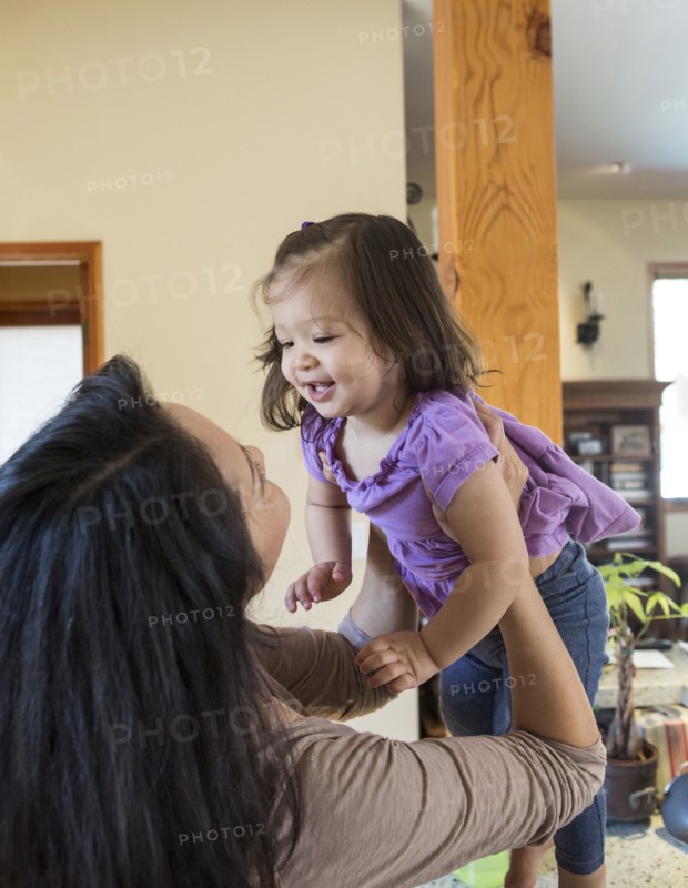 Mother holding daughter in kitchen