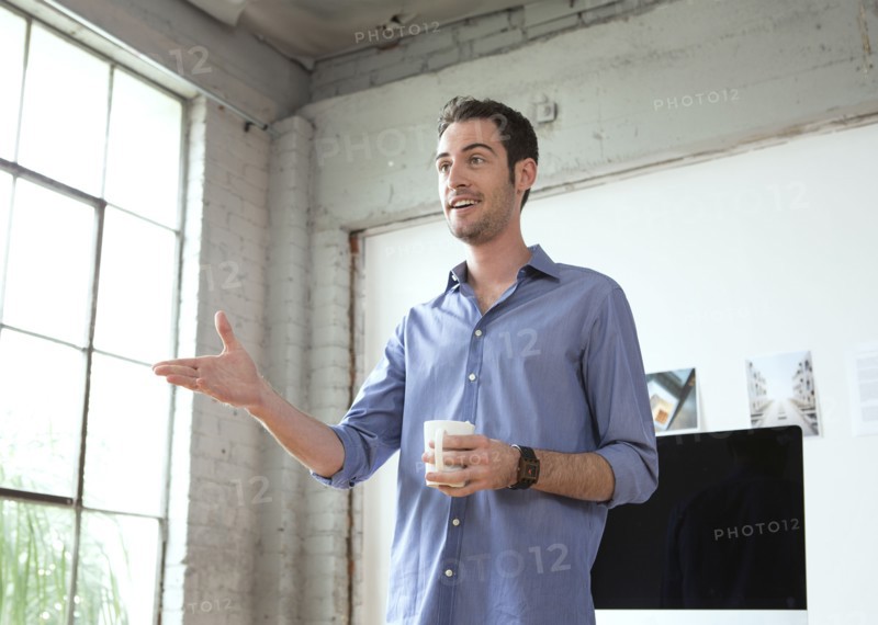 Caucasian architect drinking coffee in office