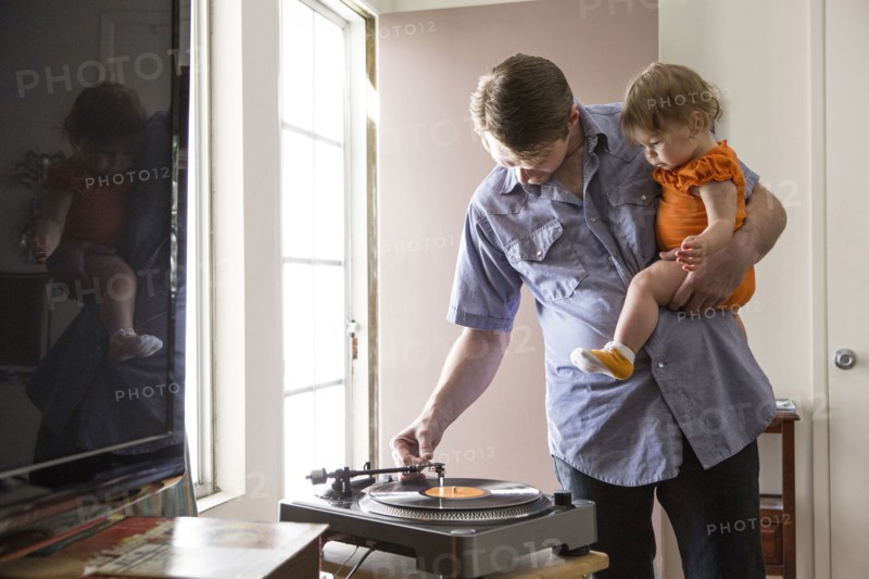 Caucasian father playing records with daughter