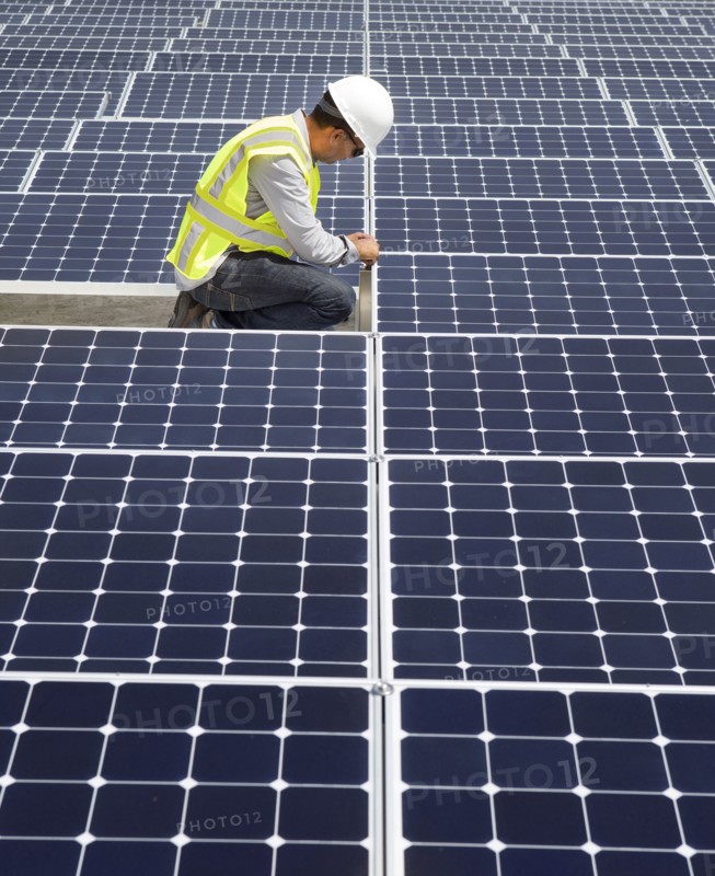 Asian technician working on solar panels