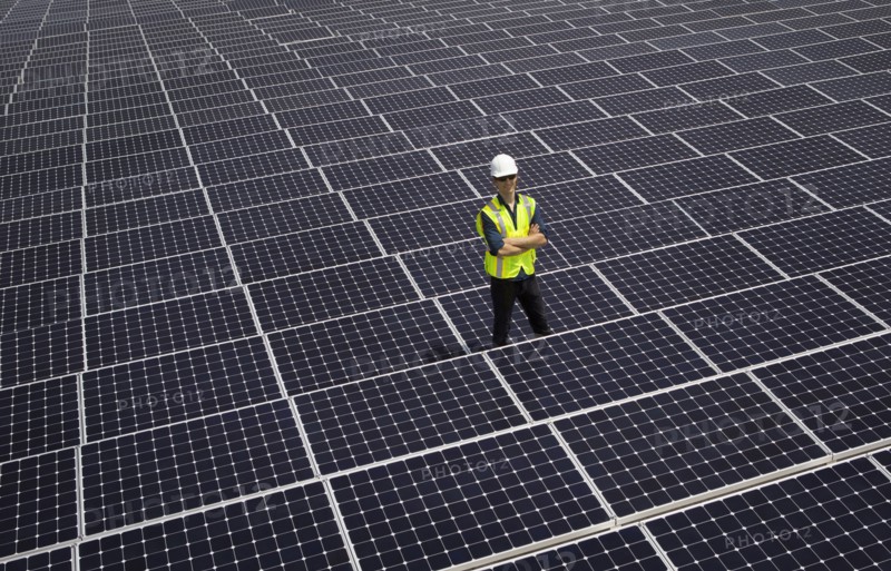 Caucasian technician smiling on solar panels