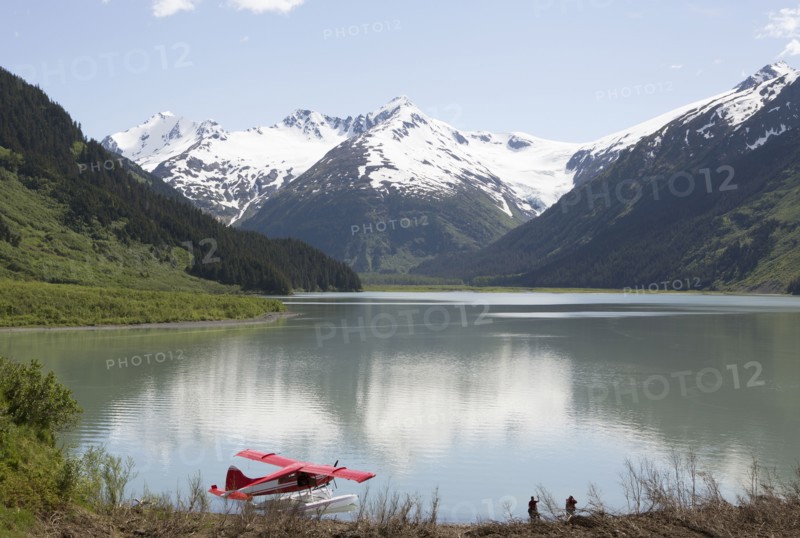 Seaplane docked in still lake in mountain landscape