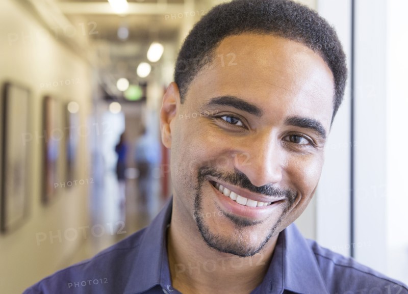 Black businessman smiling in office hallway