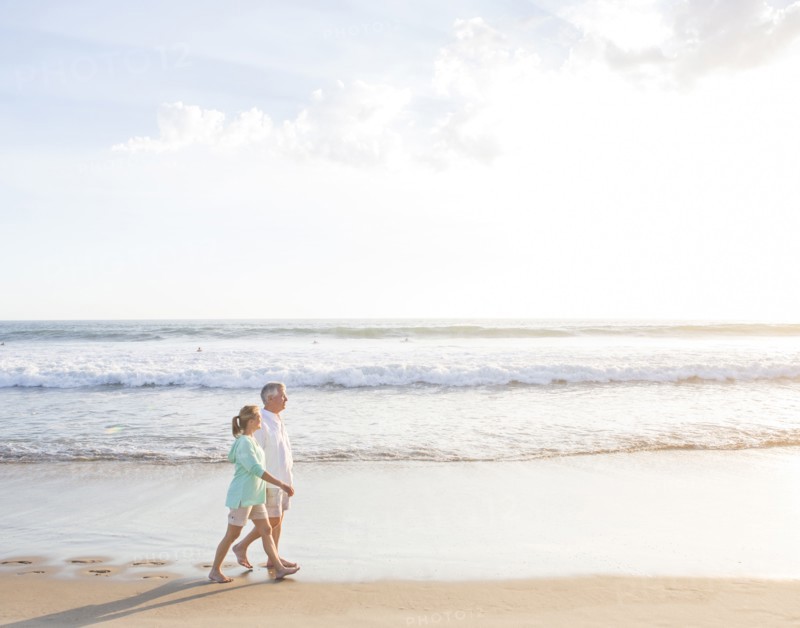 Caucasian couple walking on beach