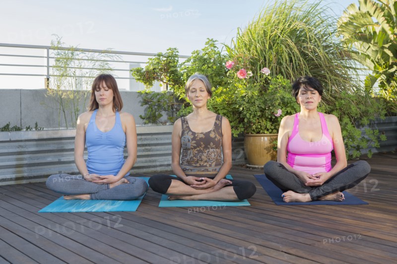 Women meditating together on urban rooftop