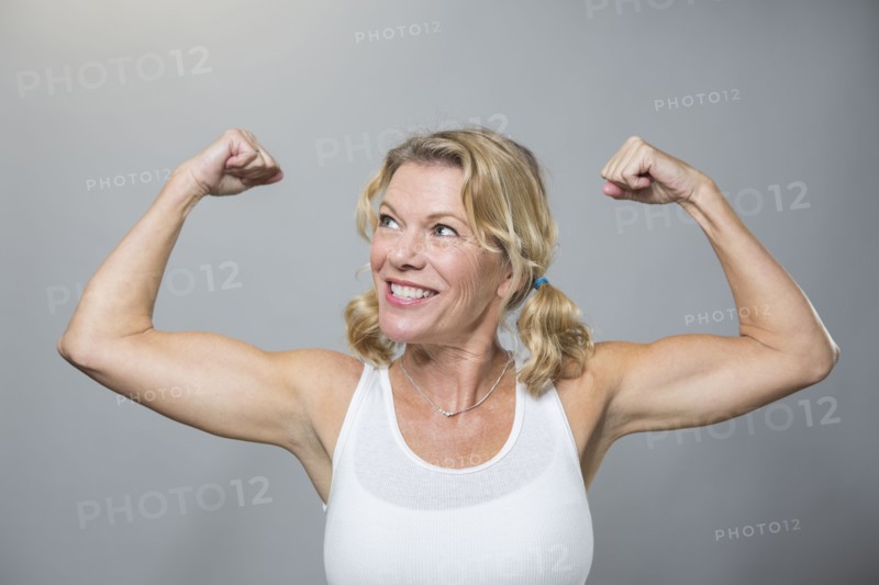 Smiling older woman flexing biceps