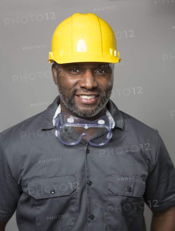 African American construction worker wearing hard hat and goggles