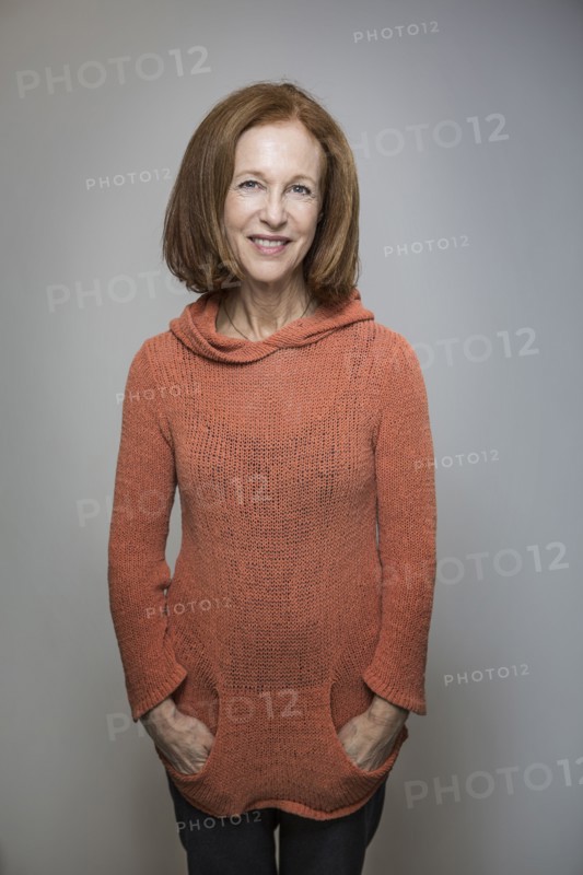 Caucasian woman smiling with hands in pockets