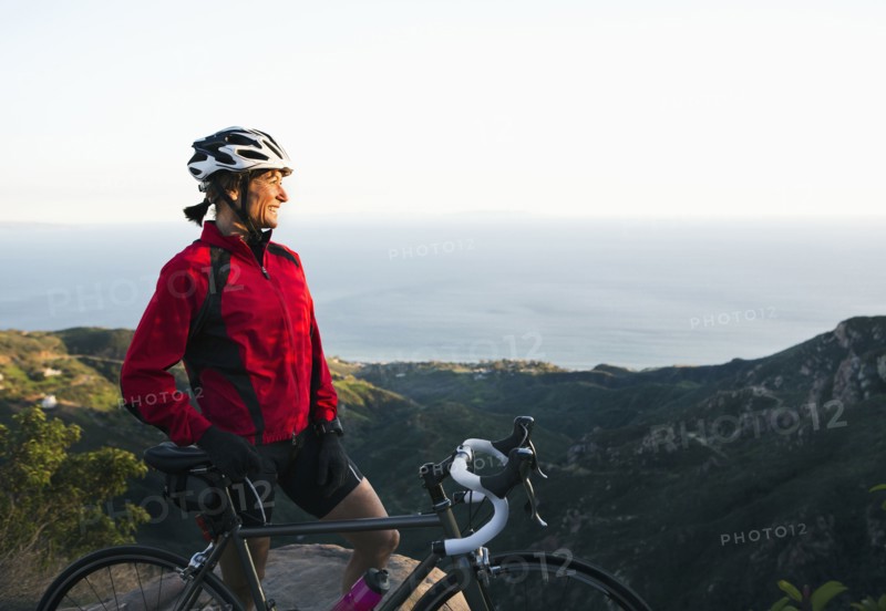 Caucasian woman with bicycle admiring scenic view of mountains