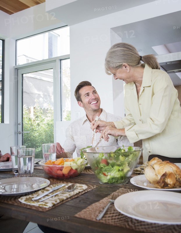 Caucasian mother serving son at table