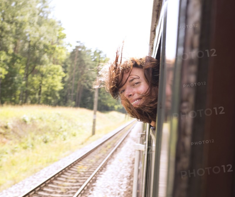 Hispanic woman with head out train window
