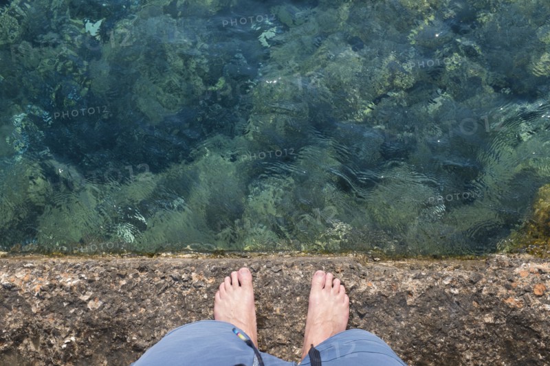 Caucasian man standing on rock wall over water