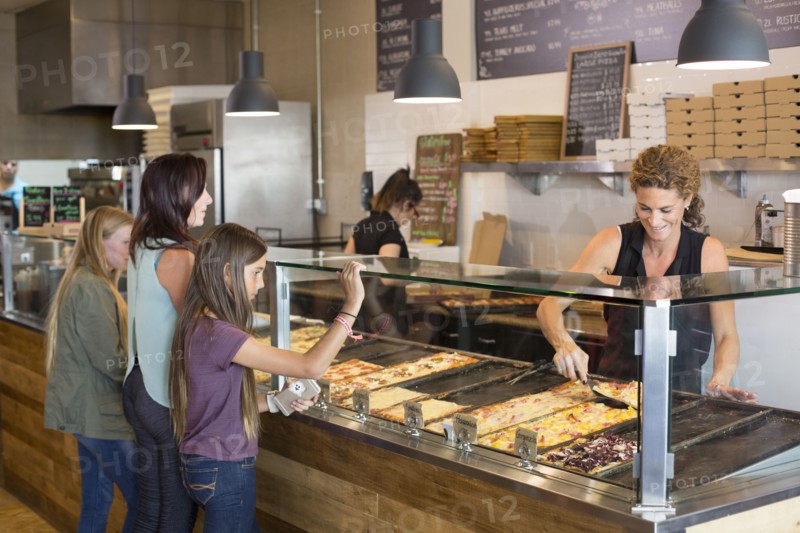 Customers choosing pizza in cafe