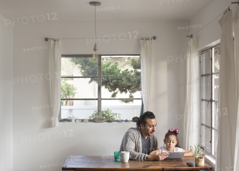Hispanic father and daughter using digital tablet