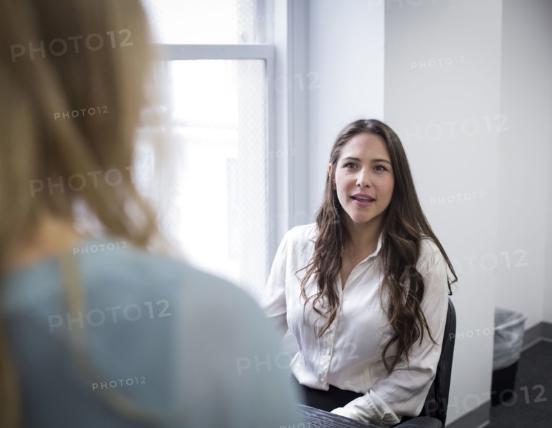 Caucasian businesswomen talking in office