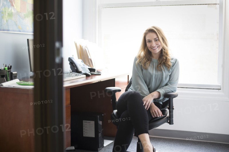 Caucasian businesswoman smiling in office