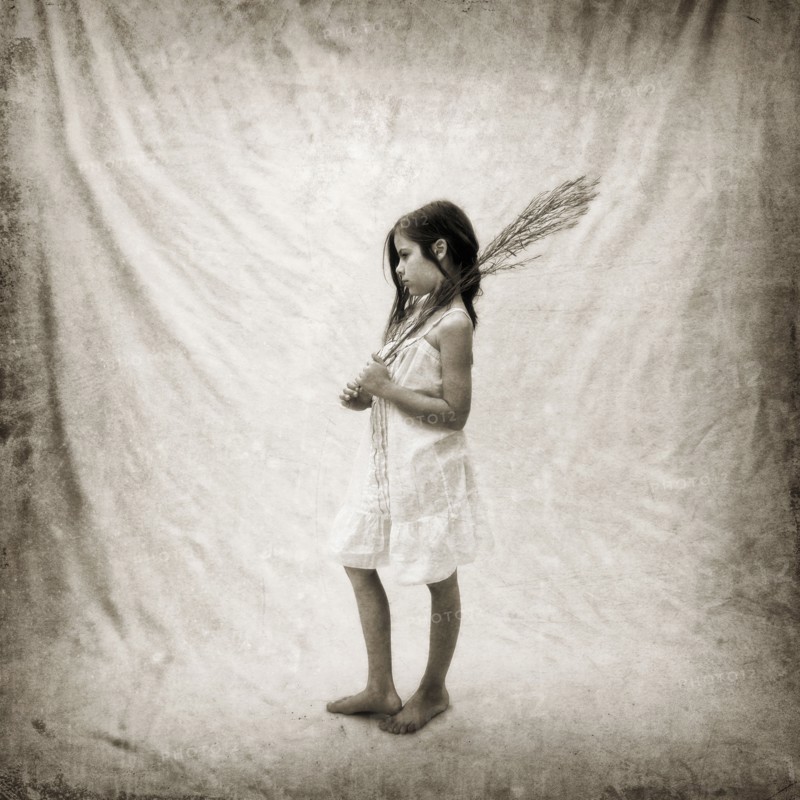 Photograph of girl holding branch on fabric