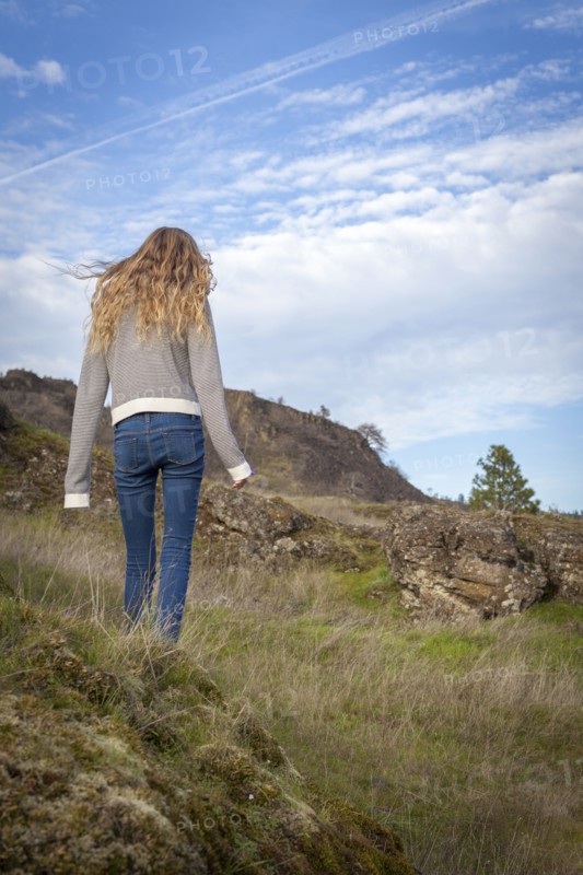 Girl walking on grassy hillside