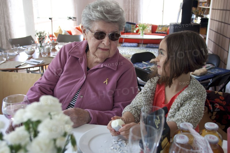 Grandmother and granddaughter cooking at table