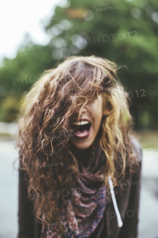 Shouting Middle Eastern woman tossing her hair outdoors