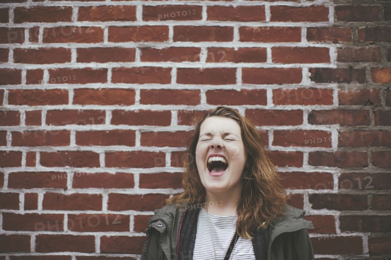 Caucasian woman shouting at brick wall