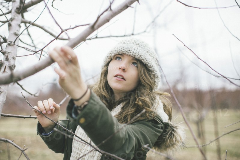 Caucasian woman examining tree branches
