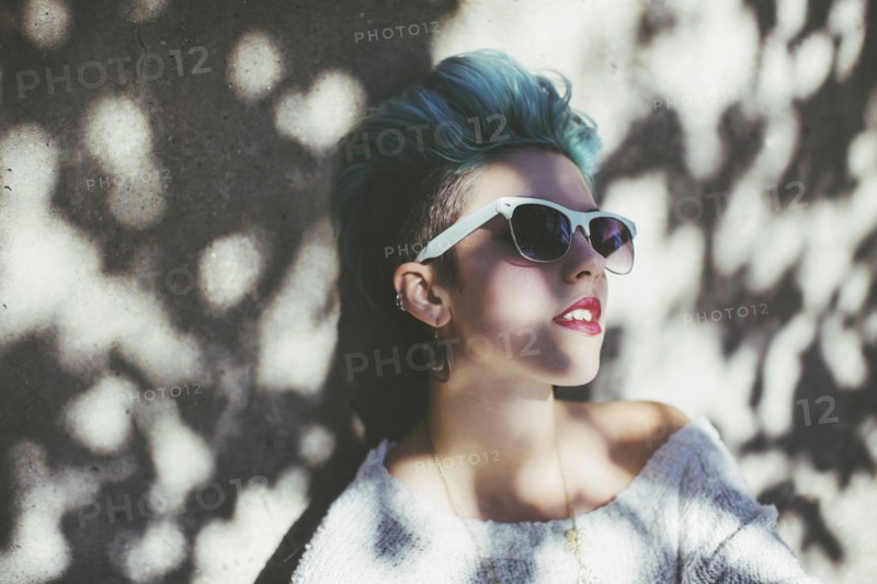 Stylish Caucasian woman wearing sunglasses in shade