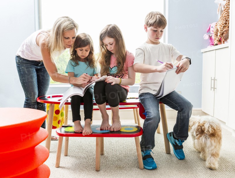 Caucasian family drawing at table in playroom