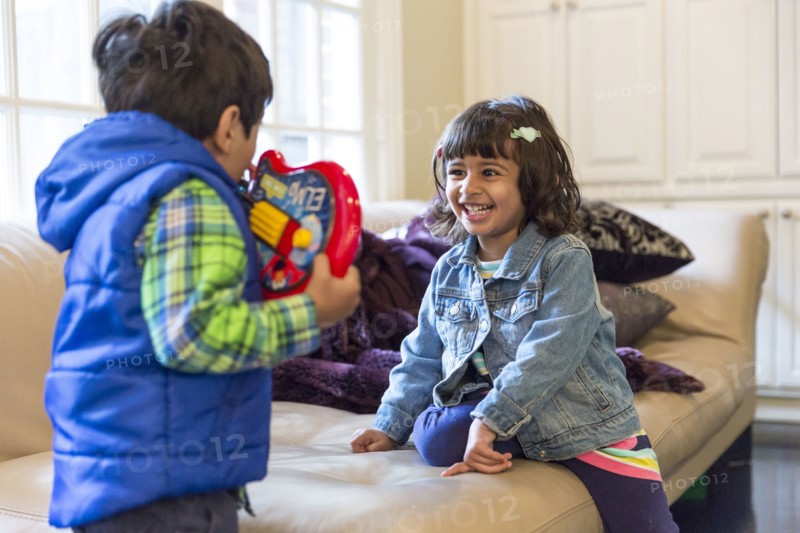 Brother and sister playing with toy in living room