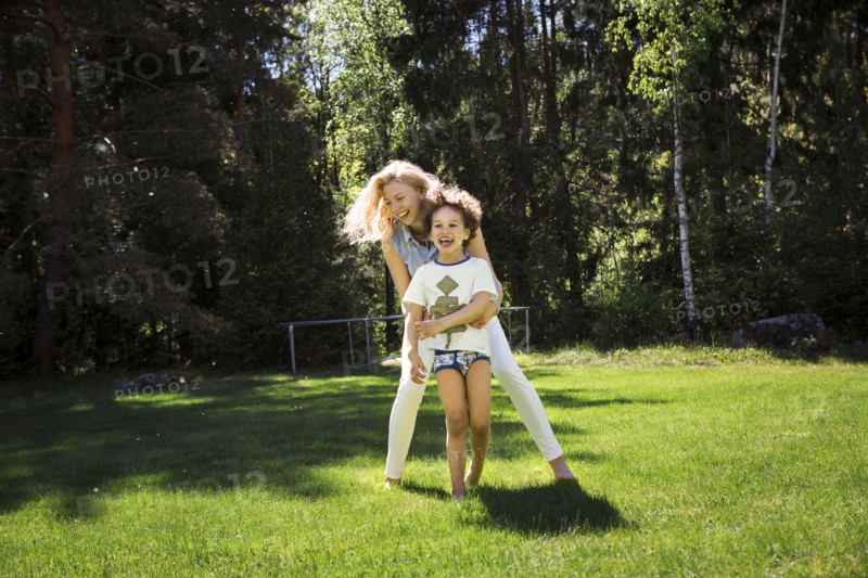 Mother playing with son in backyard