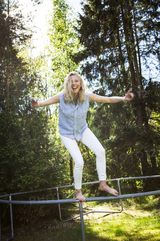 Woman jumping from metal structure in backyard