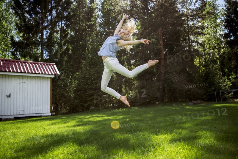Woman jumping for joy in backyard