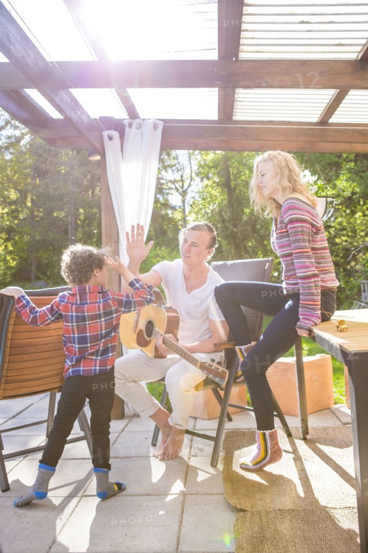 Father and son high-fiving on backyard patio