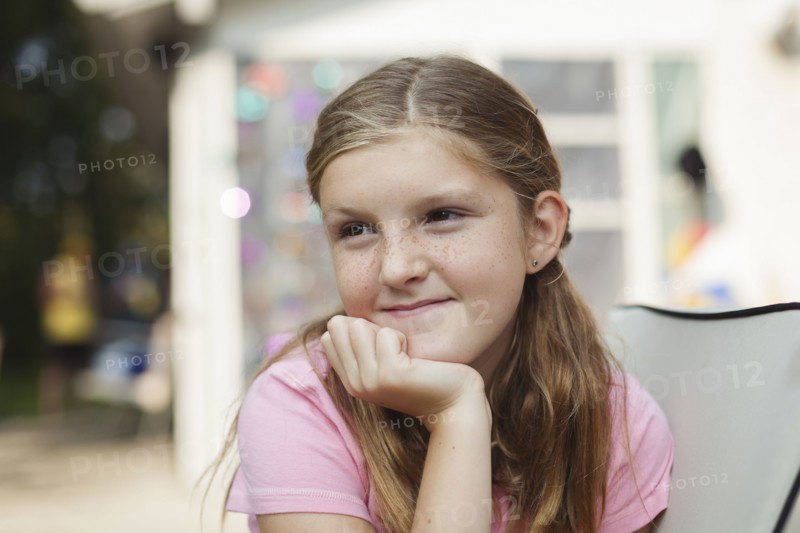 Caucasian girl resting chin in hand