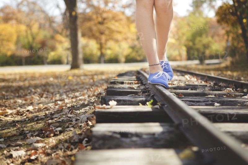 Caucasian girl balancing on train tracks