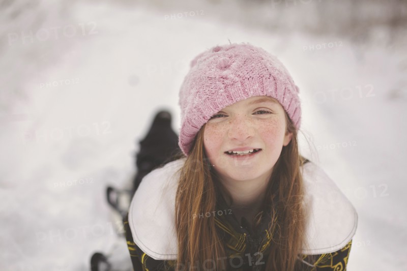 Caucasian girl laying in snow