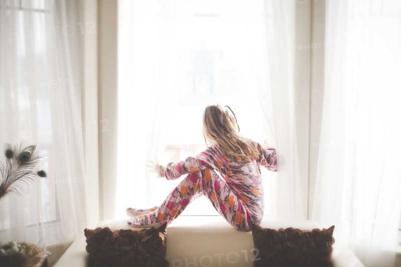 Caucasian girl sitting in window