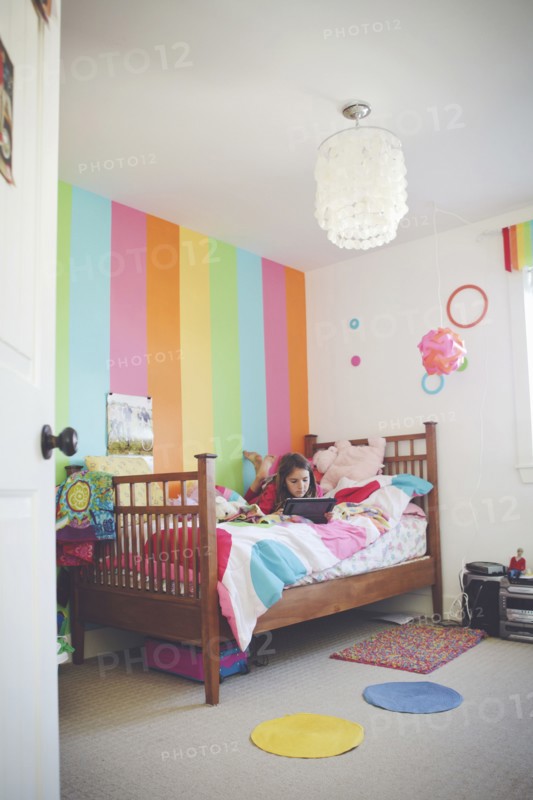 Caucasian girl using digital tablet in bedroom
